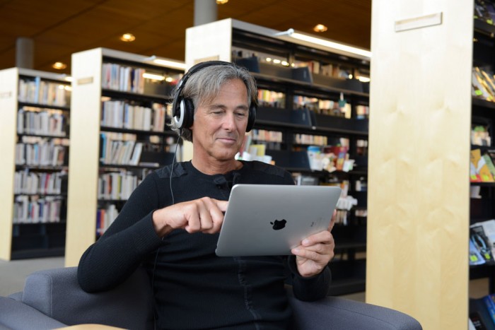 Homme avec un iPad dans une bibliothèque