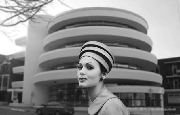 Une femme portant un chapeau devant la Caisse Desjardins sur la rue des Érables.