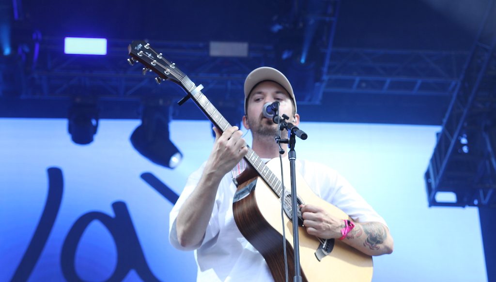 Jay Scott chante et joue de la guitare au parc de la Francophonie