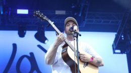 Jay Scott chante et joue de la guitare au parc de la Francophonie