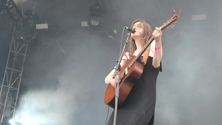 Lou-Adriane Cassidy chantant et jouant de la guitare