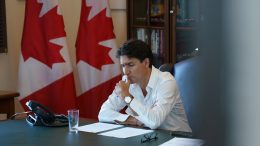 Justin Trudeau lisant des feuilles à son bureau.